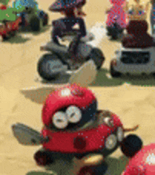 a group of toy cars and motorcycles are sitting on top of a sandy field .