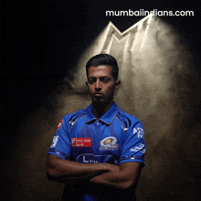 a man with his arms crossed wearing a blue shirt that says indians