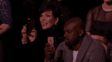 a woman is taking a picture of a man with her cell phone