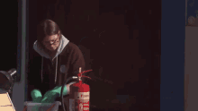 a woman is using a red foam fire extinguisher