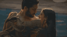 a man and a woman are kissing and the woman is wearing earrings