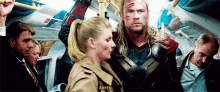 a man in a superhero costume is talking to a woman on a bus ..