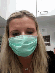 a woman wearing a green face mask is standing in front of a sign that says ups express