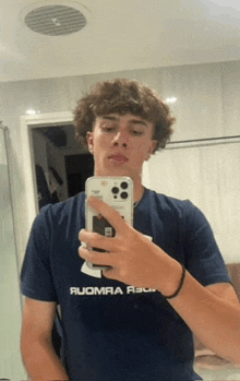 a young man is taking a picture of himself in a mirror with his phone