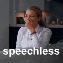 a woman sits on a couch covering her mouth with her hand and the word speechless is on the bottom right