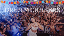 a woman stands in front of a crowd of people with the words dreamchasers written above her