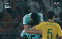a man in a number 15 jersey is hugging another man in a number 2 shirt