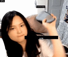 a woman is holding a container in front of a screen that says " covid19 6 days "