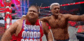 two wrestlers are posing for a picture together in a wrestling ring .