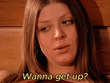a close up of a woman 's face with the words " wanna get up " above her