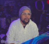 a man wearing glasses and a beanie has a red lip on his face