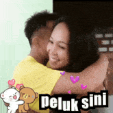 a picture of a man and woman hugging with the words peluk sini below them