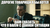 a man in a suit and tie lighting a cigarette with a foreign language caption behind him