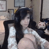 a woman wearing headphones is sitting in a chair in front of a computer .