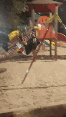 a person is swinging on a rope swing in a playground