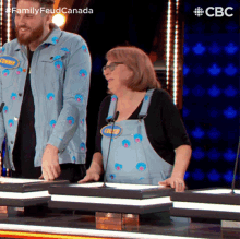 a man and a woman are playing a game on a television show called family feud canada