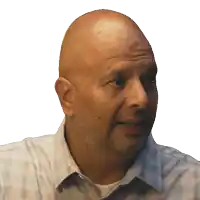 a bald man with a beard is wearing a white shirt