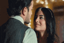 a man and a woman are looking at each other in a room .