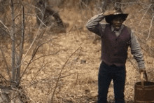a man in a cowboy hat is holding a wooden bucket