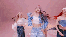 a group of three women are dancing together in a room .