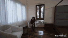 a woman sits in a chair in a room with the words made in animotica on the bottom right