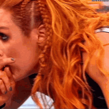 a close up of a woman 's face with a braided ponytail .