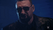 a man with a beard wearing sunglasses and a leather jacket