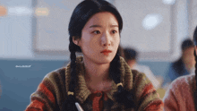 a girl with pigtails is sitting in a classroom with a caption that says gnlvb2b0f