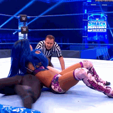 a woman in a wrestling ring with a sign that says smack down on it