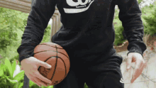 a man wearing a black shirt with the number 3 on it holds a basketball in his hands