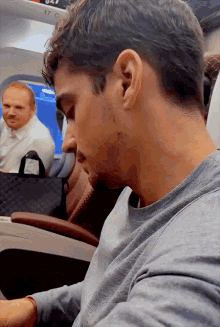 a man sitting on a plane with the number 17 on the side of the plane