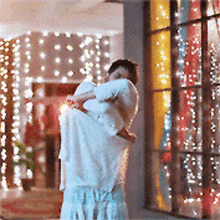 a man is holding a woman in his arms in front of a stained glass window .