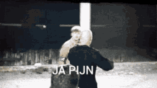 a man in a black shirt is standing next to another man with the words ja pijn written on the bottom