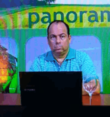 a man sitting in front of a sign that says panorar