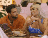a man and a woman are sitting at a table and talking .