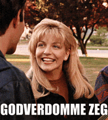 a woman is smiling in front of a sign that says godverdomme zeg on it
