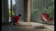 a child in a red sweater is crawling on the floor next to a chair