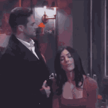 a man and a woman are looking at each other in a dark room
