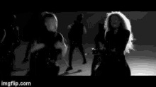 a black and white photo of a group of women dancing