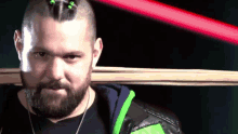 a man with a beard is holding a wooden stick