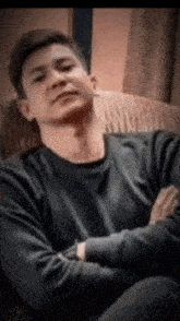a man with his arms crossed is sitting in a chair