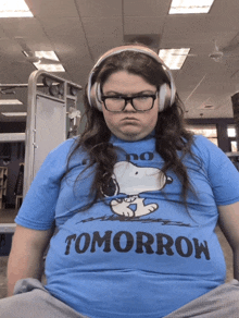 a woman wearing headphones and a blue shirt that says tomorrow