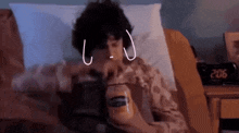 a person is laying in bed with a jar of peanut butter and a clock that says 206