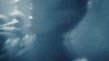 a close up of a person 's face in a dark room with a light behind them