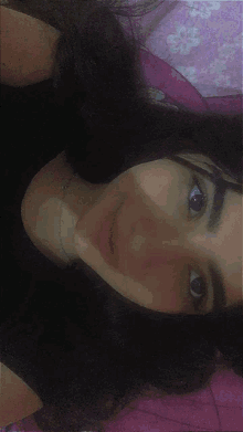a close up of a woman 's face with a pink background