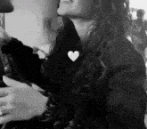 a black and white photo of a woman with a heart on her chest .