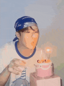 a man wearing a bandana blows out a candle on a pink birthday cake