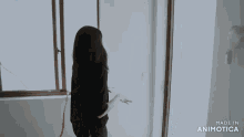a woman is standing in front of a window with the words made in animotica below her