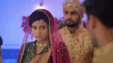 a bride and groom are standing next to each other in a room .