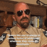 a bald man wearing sunglasses and a sheriff 's uniform